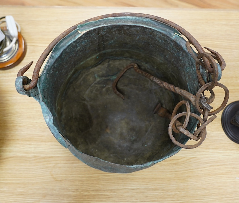 A 17th / 18th century copper cooking pot, 29cm to top of handle. Condition - poor